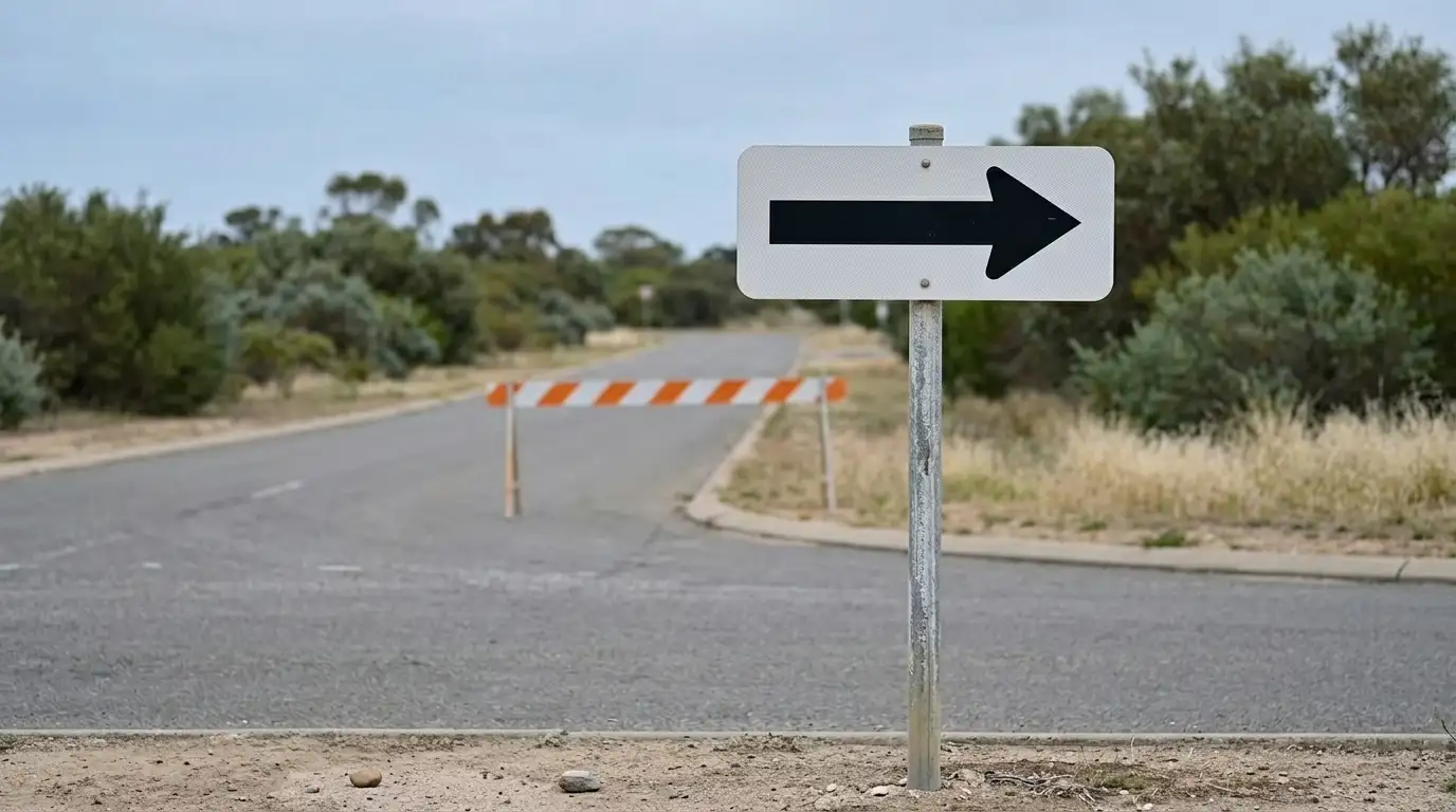 One-way road sign at a junction, the return lane marked closed